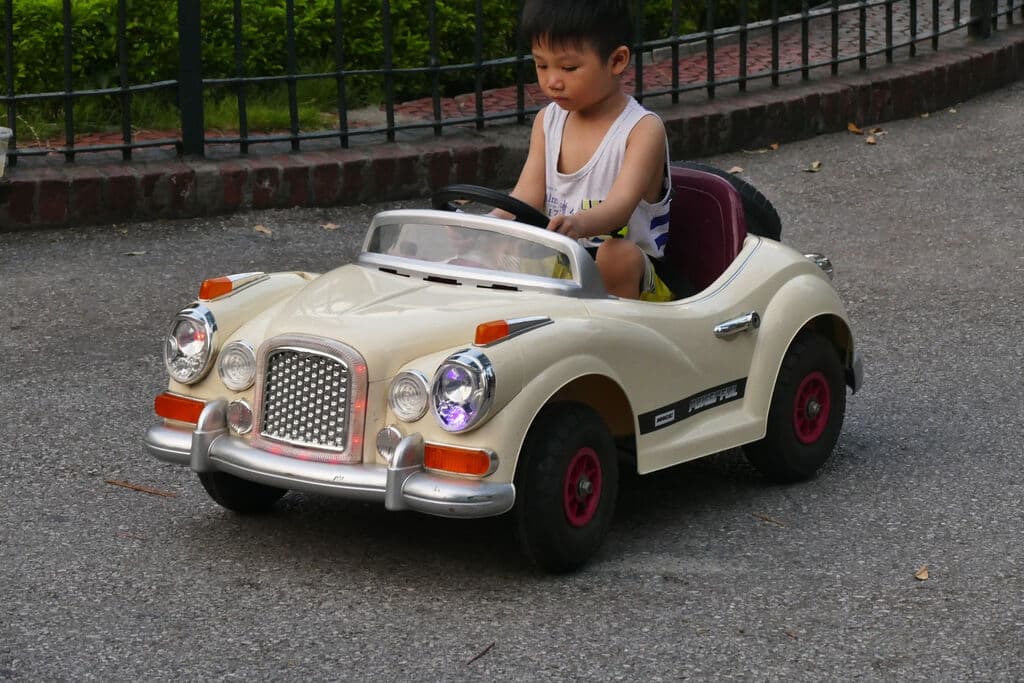 Niño conduciendo un coche de juguete