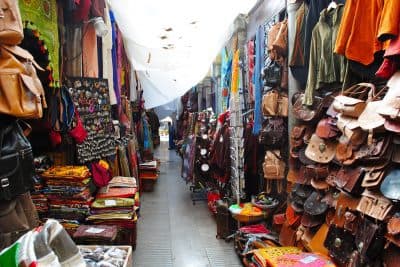 Narrow street at Granada's bazaar displaying artisan arab leather products to shop